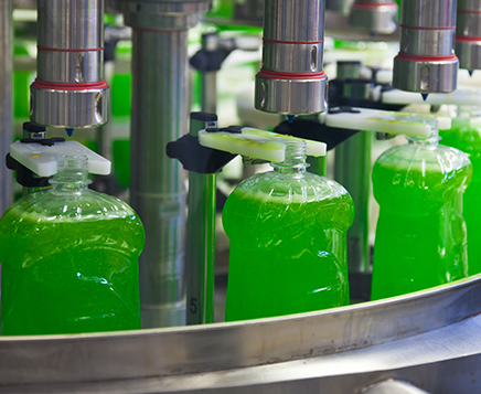 Plastic bottle filled with green liquid in a factory