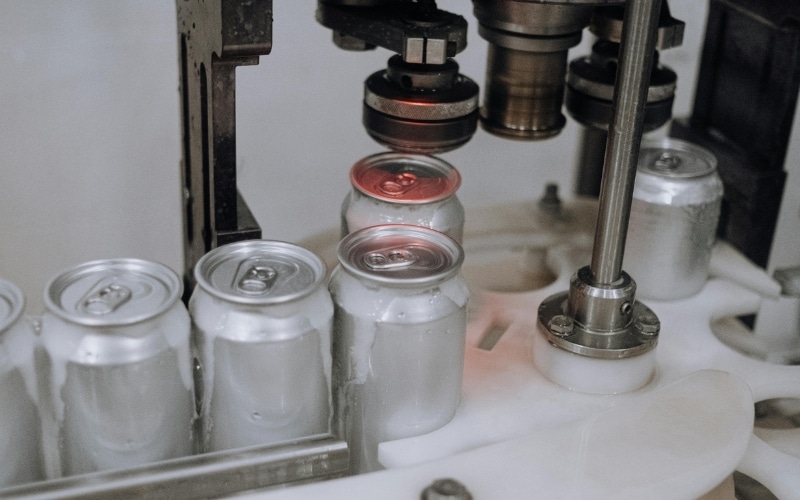 Cans run through an assembly line at a packaging facility.