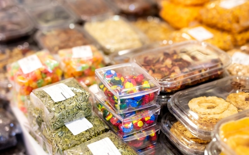 Dry foods packaged and labeled on a table in a grocery store.