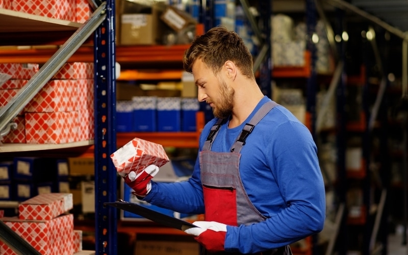 A gentleman examines a solid product package in a packaging facility