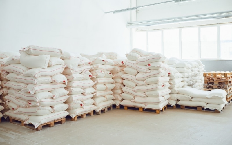 Pallets of flour sit in a warehouse.