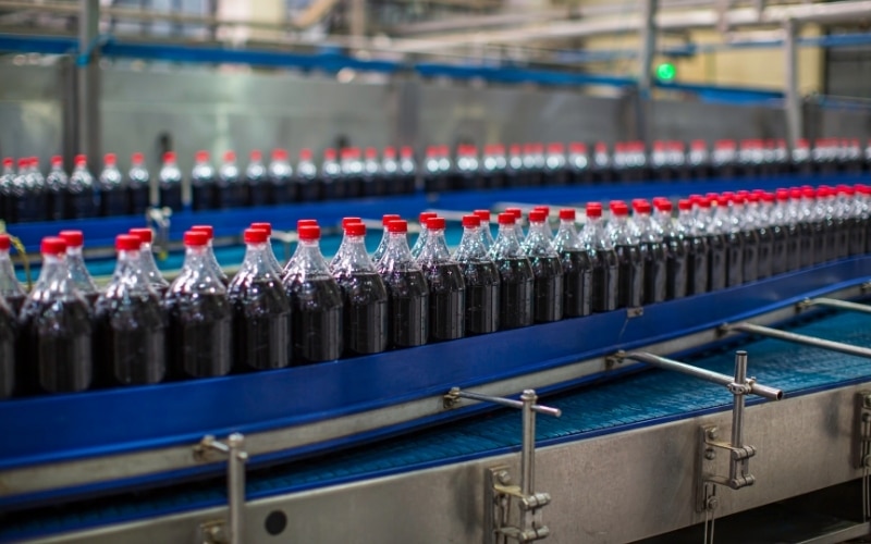 A number of soda bottles are filled with an automatic filling machine.