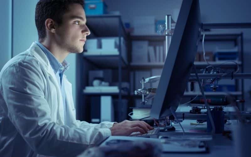A worker uses a computer to allocate resources for a contract manufacturing project.