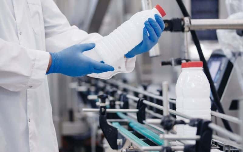 A quality control employee inspects a product at a contract manufacturing facility.