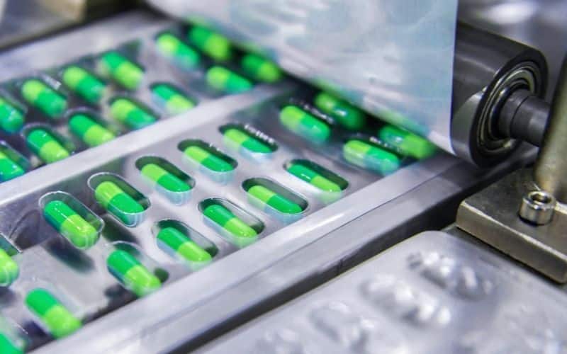 An image of pills being packaged at a contract manufacturing facility