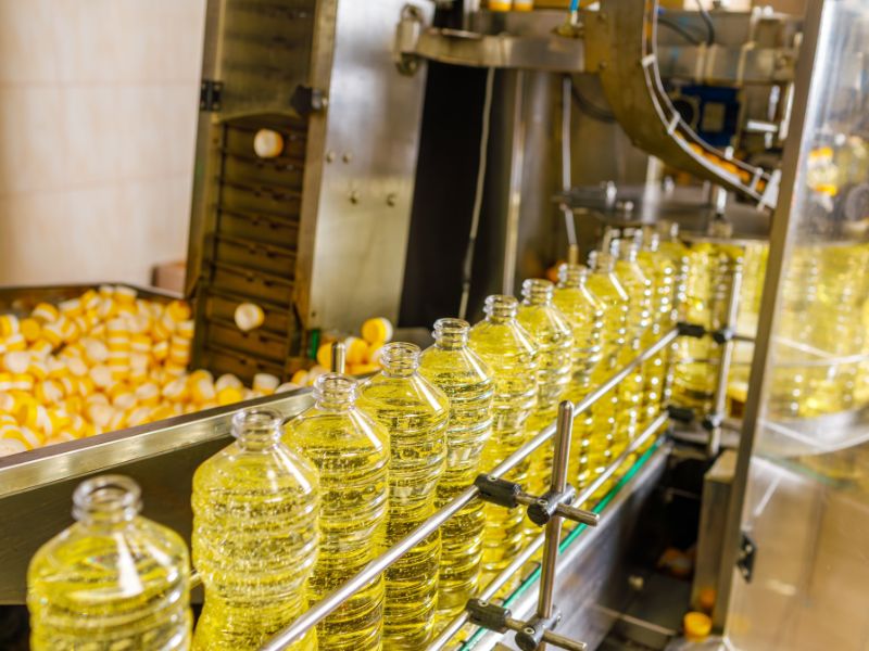 Bottles of oil are filled in a toll manufacturing facility