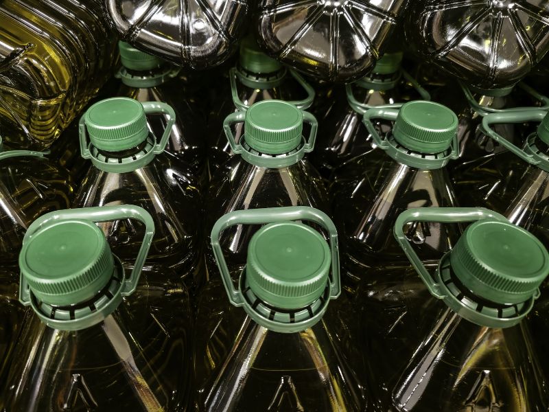 Plastic bottles with green lids are packaged and waiting to be shipped from a packaging facility.