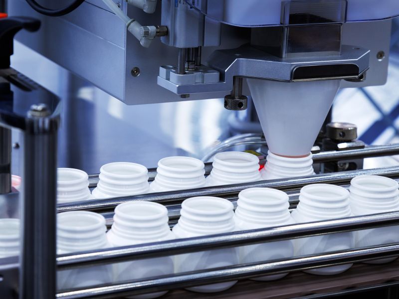 White plastic pill bottles are filled at a contract manufacturing facility.